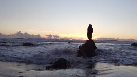 Stunning-view-of-the-sunset-at-low-tide-in-Laguna-Beach-as-the-sun-peaks-out-amongst-rocks-and-reflects-off-the-water