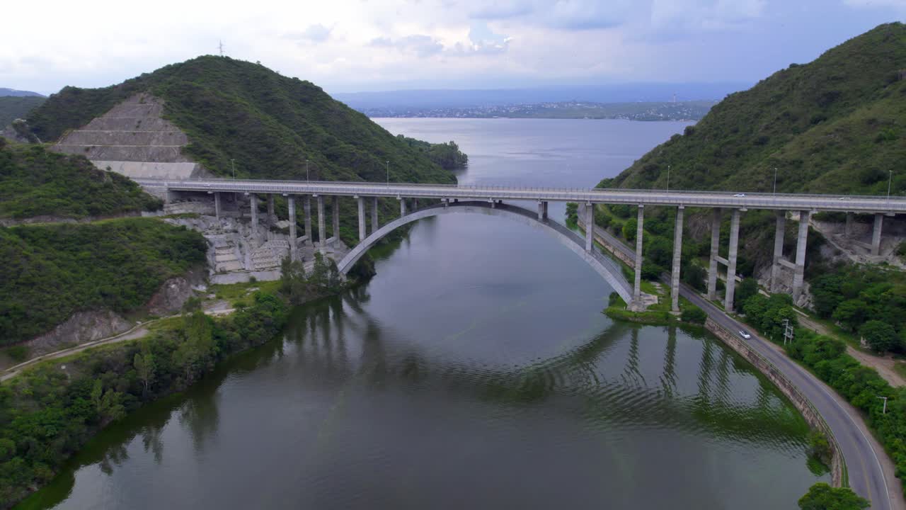 Aerial view of new viaduct over lake surrounded by green mountains. Córdoba, Argentina