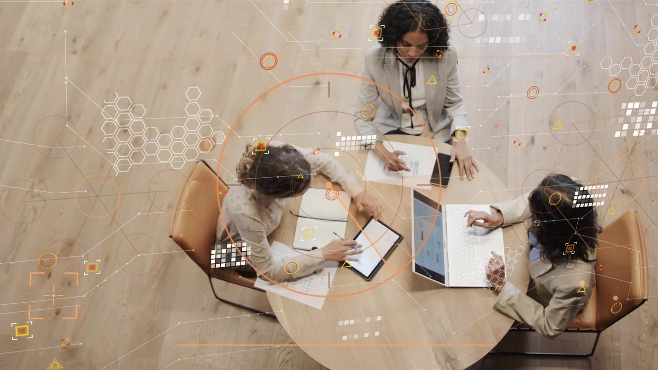Business team meeting tapping tablet, noting, syncing laptop, activating HUD for data review