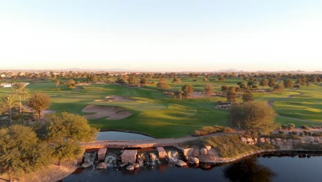drone footage from a golf course near a residential neighborhood in arizona. high to low aerial shot from a shot of the greens to the water hazard