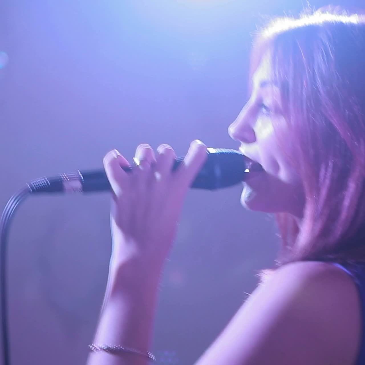Woman singing on dark stage