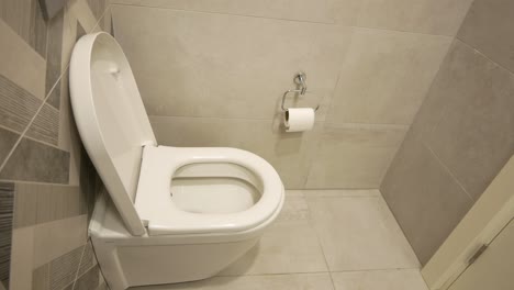 modern white toilet in a light gray tiled bathroom