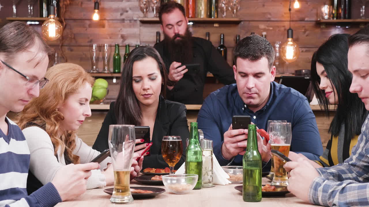 Group of people using phones at restaurant