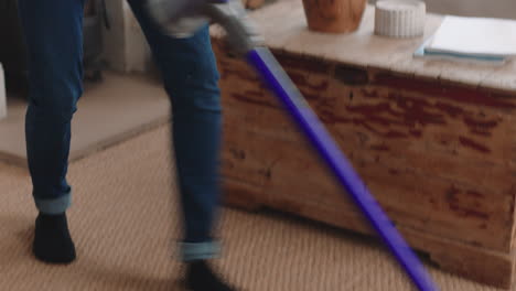 happy young man dancing at home using vacuum cleaner celebrating success having fun dance cleaning living room on weekend