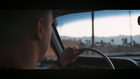 Young-man-driving-classic-car,-over-shoulder-view,-close-up