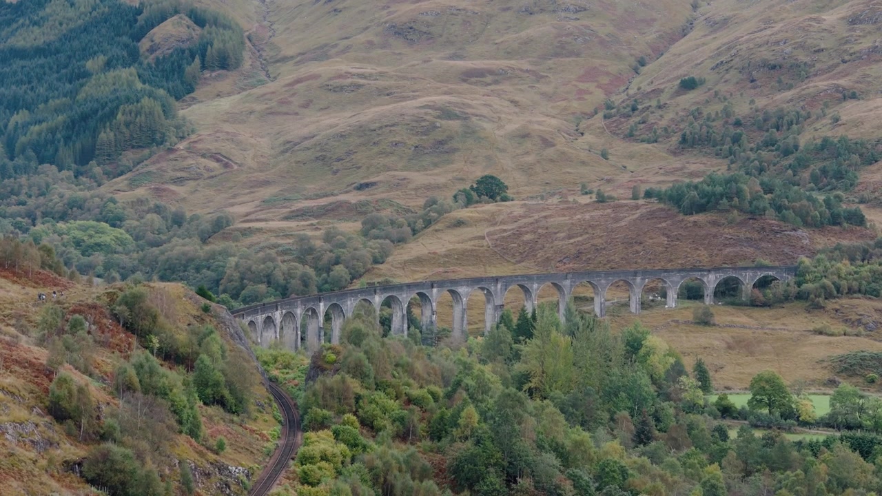 Stigende opptak av Glenfinnan viadukt med en gradvis avsløring av høylandets landskap.