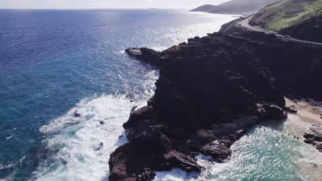 Imágenes-Aéreas-Dando-Vueltas-Alrededor-De-Una-Península-Rocosa-Mientras-Las-Olas-Blancas-Del-Océano-Pacífico-Chocan-A-Lo-Largo-De-La-Costa-Rocosa-Mientras-El-Agua-Turquesa-Se-Asienta-Pacíficamente-En-La-Aislada-Cala-De-La-Playa-De-Halona.