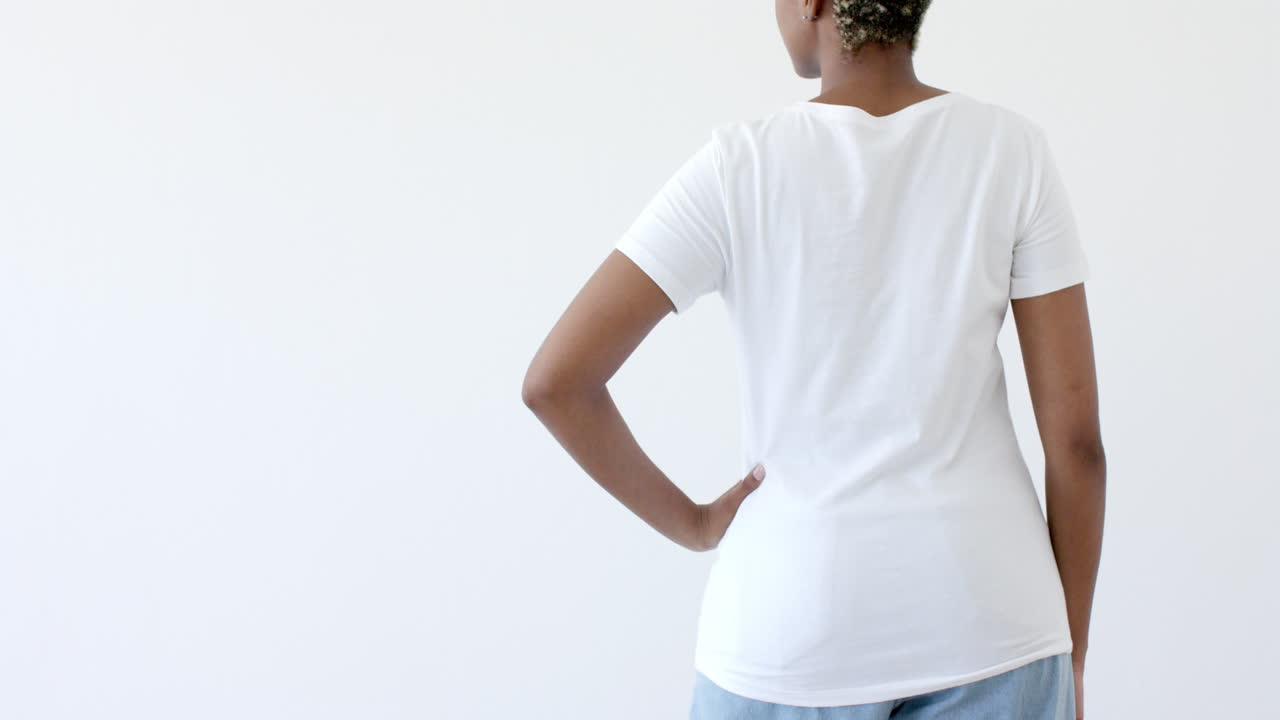 sección media de una mujer afroamericana vestida con una camiseta blanca con espacio de copia en un fondo blanco