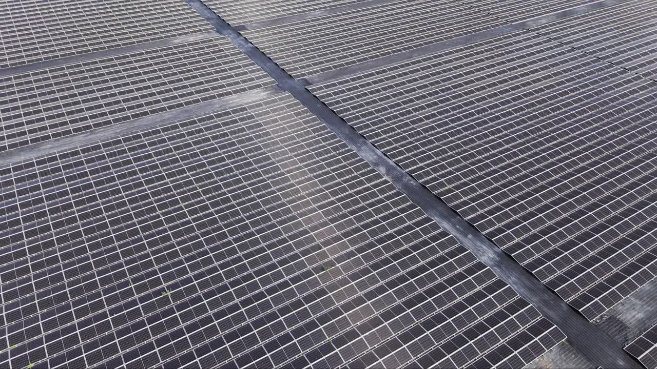 Ampia prospettiva aerea da drone di un grande impianto solare con molti pannelli fotovoltaici allineati
