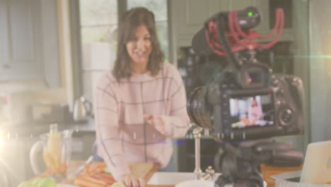 animación de luz brillante sobre la cámara con una vlogger femenina grabando un vlog culinario en casa