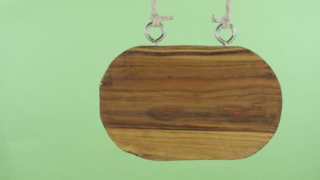 panorama, of a hanging wooden sign. isolated on green screen.