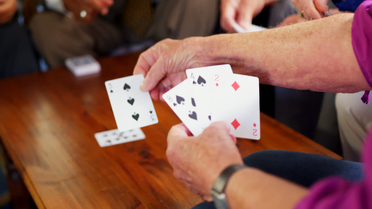 sección media de personas mayores jugando a las cartas en el hogar de ancianos 4k