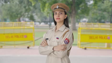 portrait of indian female police officer standing crossed hands