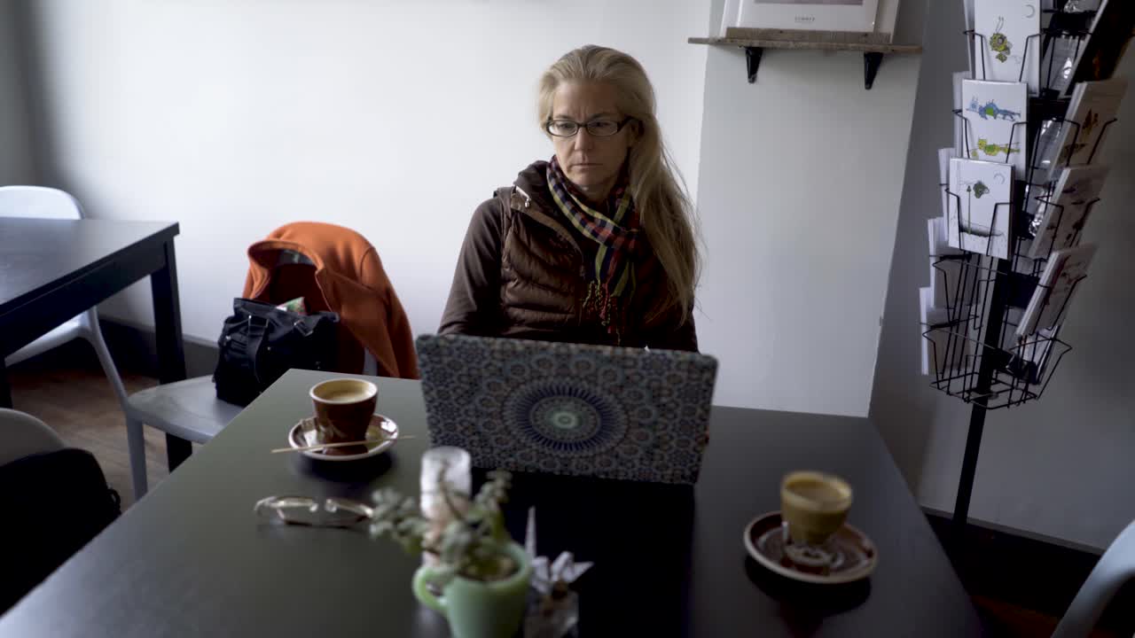 женщина работает на ноутбуке в кафе