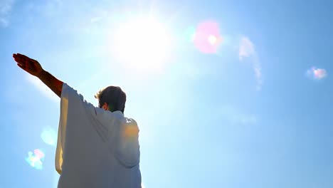 man with arms outstretched towards the sun