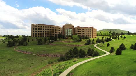 Eine-Pullback-Drohnenaufnahme-Eines-Großen-Städtischen-Gebäudes-In-Golden-Colorado