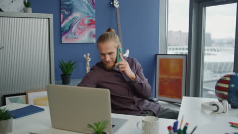 Positive-manager-talking-phone-in-office-closeup.-Businessman-reading-laptop