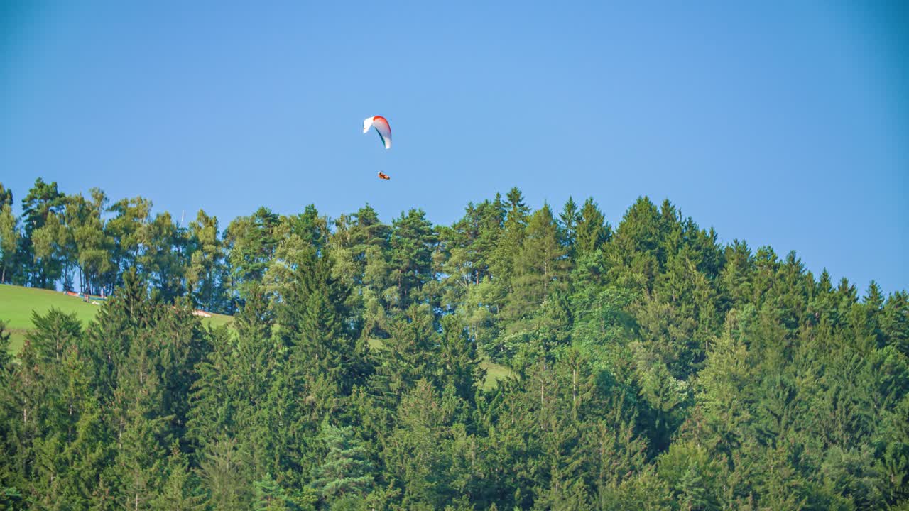 Colourful Paraglider Soaring High Above Treeline. Dangerous Extreme Sports