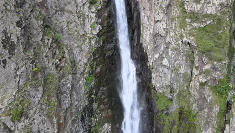 Aerial-shot-of-waterfall-surrounded-by-rocks