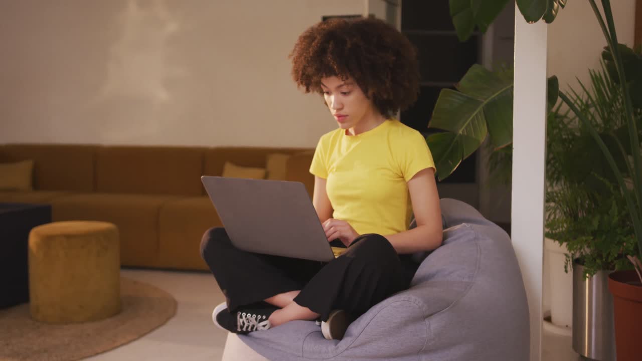 Mixed race woman working on computer in creative office