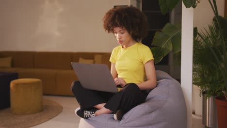 mixed race woman working on computer in creative office