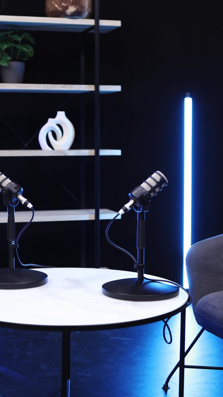 Prázdné podcastové studio s mikrofony a modrým osvětlením