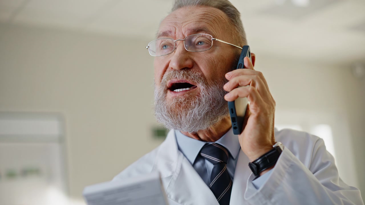 Qualified doctor talking smartphone giving consultation to patient portrait
