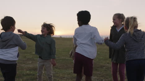 group of happy kids portrait playing jumping cheerful celebrating in grass field at sunset enjoying fun games together