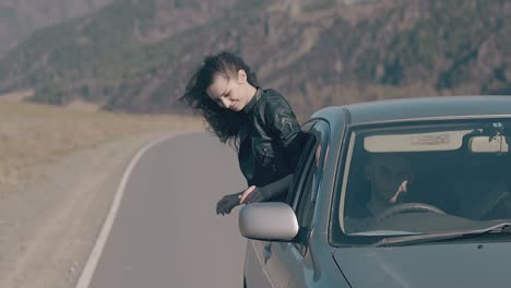 beautiful-brunette-in-leather-jacket-sits-on-car-window