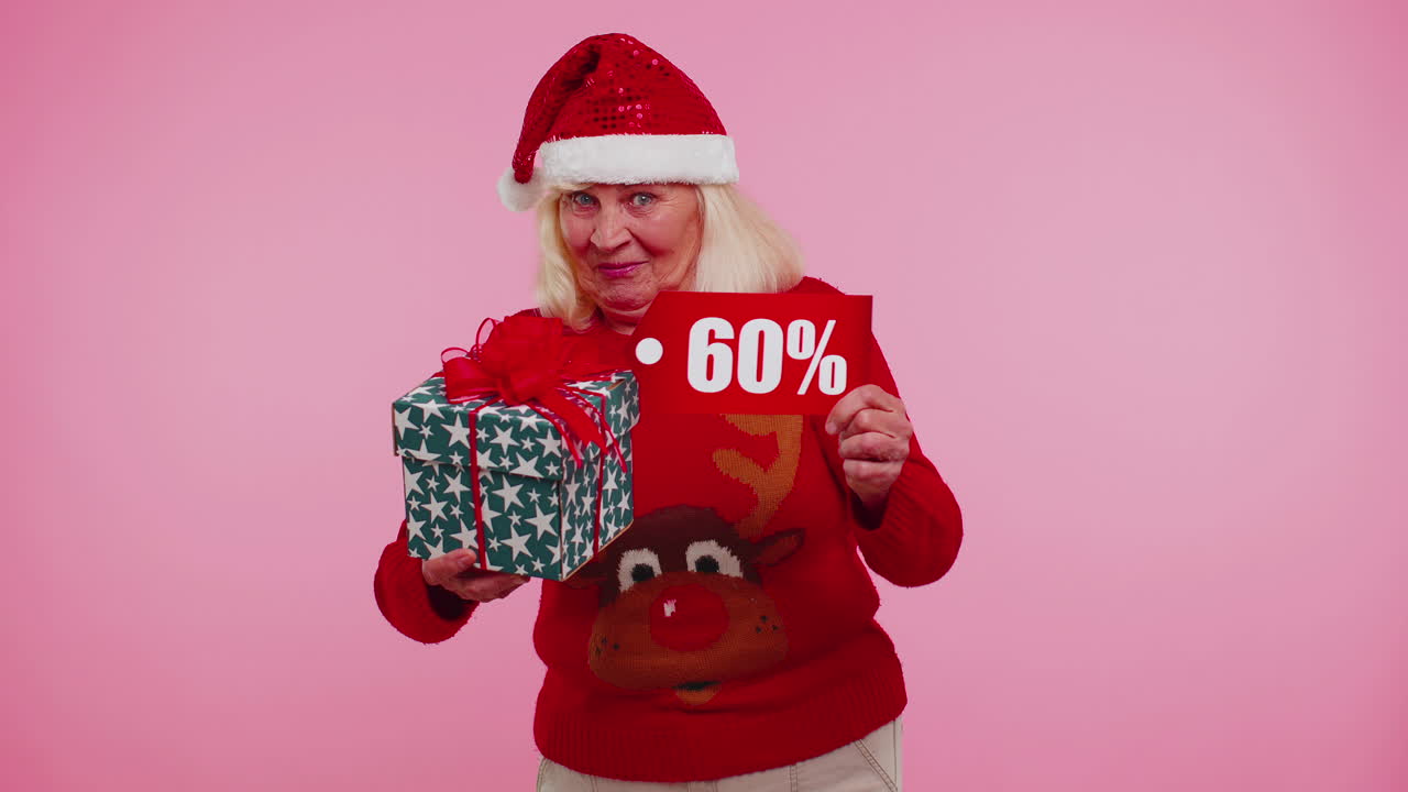 abuela en suéter de navidad mostrando caja de regalos y 60 por ciento de descuento inscripciones texto de pancarta