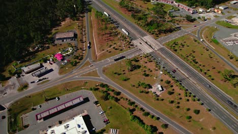 Aerial-view-of-semi-truck-stop-beside-of-busy-highway-in-Jasper,-Florida