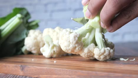 cutting cauliflower on a wooden board