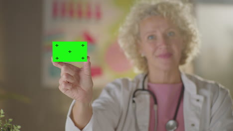 doctor holding green screen card
