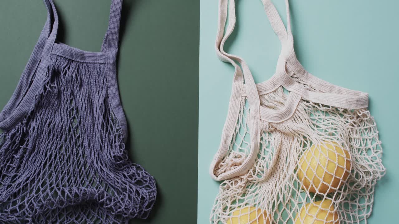 녹색과 파란색 배경에 레몬과 복사 공간을 가진 파란색과  ⁇ 색 가방의 비디오