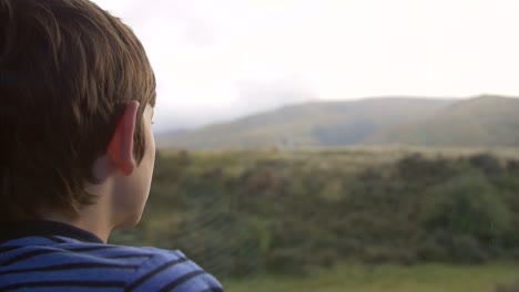 young boy looking out of a coach window