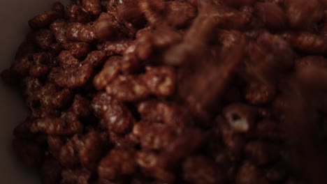 detail of chocolate cereals falling into a bowl