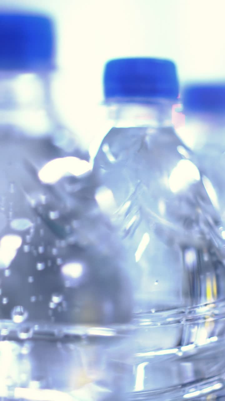 Bottled water with blue caps arranged in a row, showcasing clarity and freshness, ideal for hydration and healthy lifestyle concepts