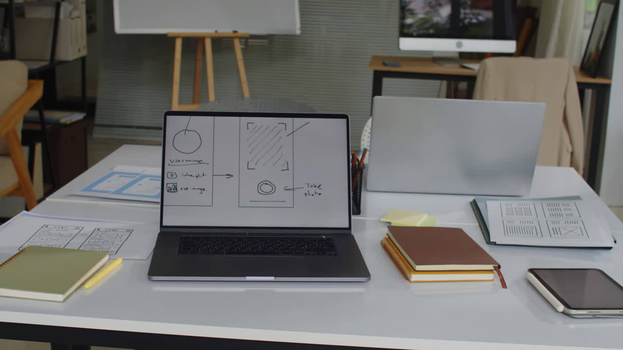 Working Table of Graphic Designer with Website Mockup on Screen of Laptop