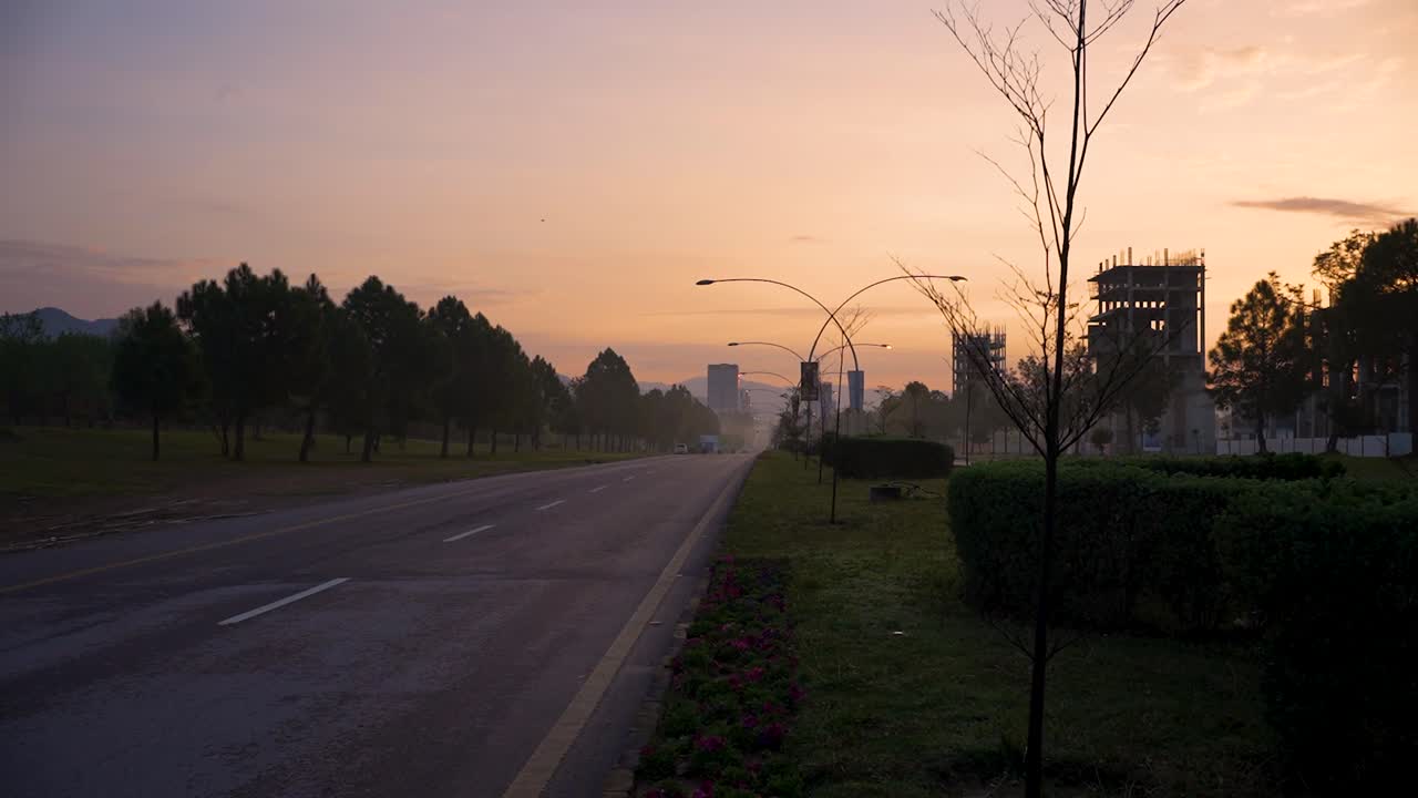 A beautiful cinematic morning view of Islamabad with a yellowish sky with sunrise and buildings under construction on Margalla Road no people