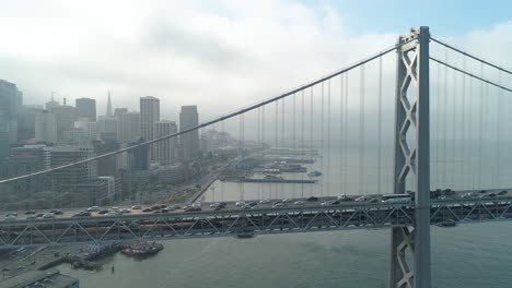 aerial shot of vehicles moving on san francisco–oakland bay bridge with city in background
