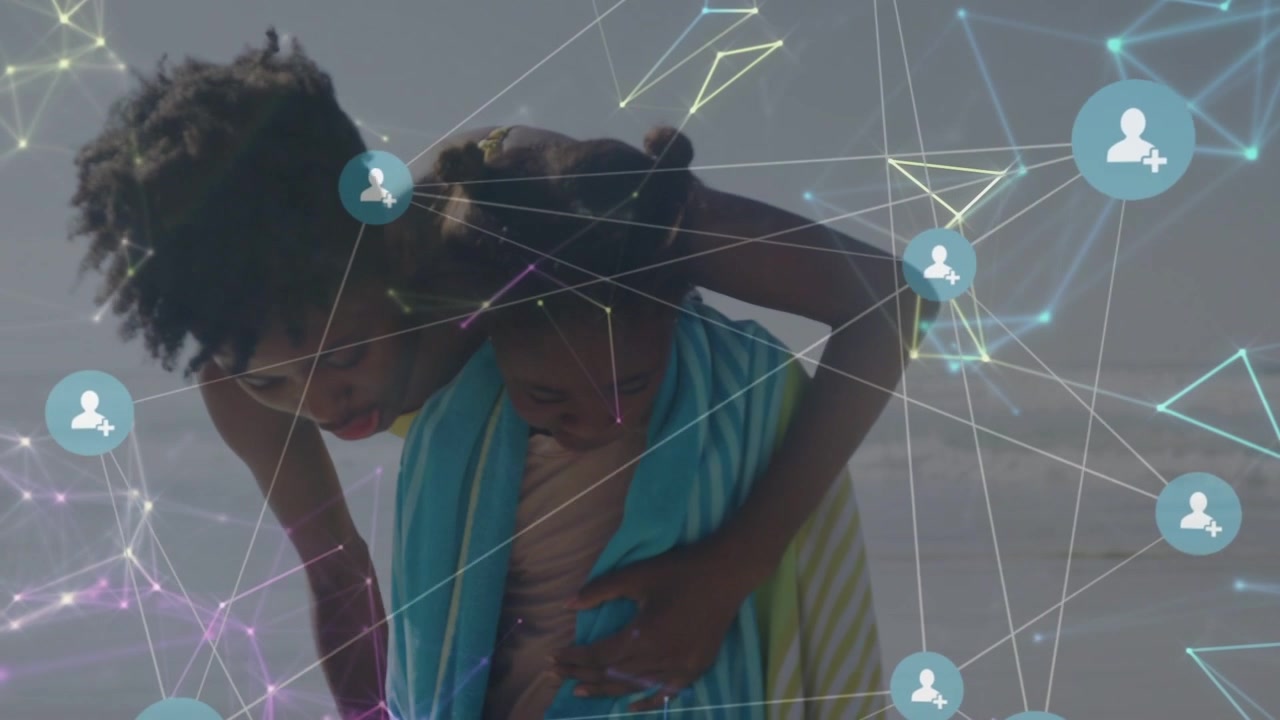 Caregiver leaning forward wrapping child with teal towel on beach, network overlay scene for health