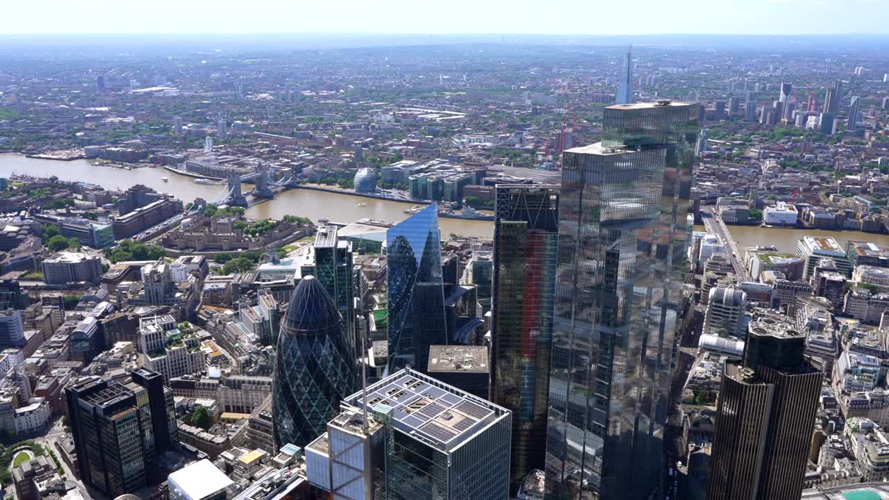 Aerial from the River Thames and the Tower of London to Fenchurch Street Station and onto the City of London towers of Leadenhall and the Gherkin. London UK.