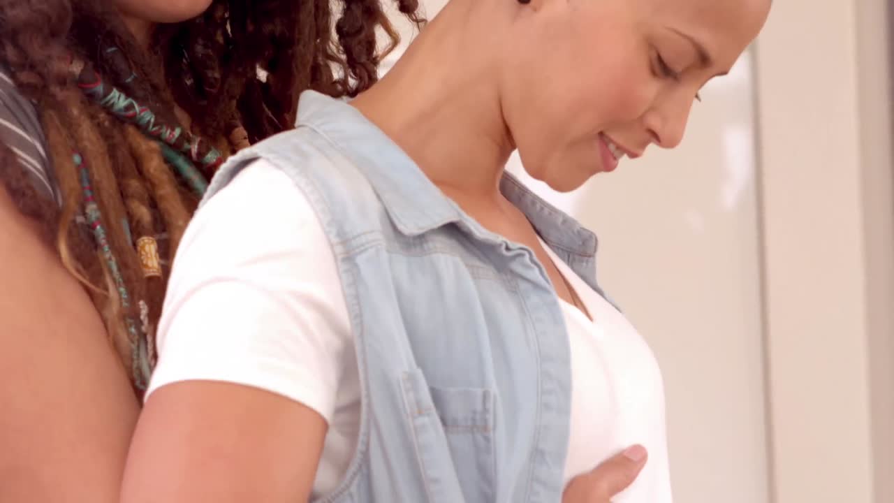 pareja feliz de lesbianas tocando el vientre de mujeres embarazadas