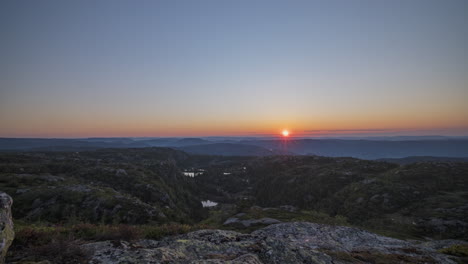 time lapse sun rises from horizon over scenic mountain wilderness, norway