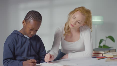 niño en el espectro del tda en casa siendo ayudado o evaluado por una tutora doméstica o una psicóloga educativa