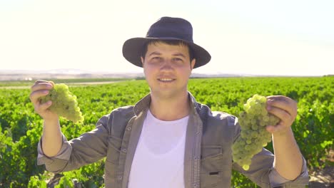 Farmer-with-grapes-looking-at-camera.