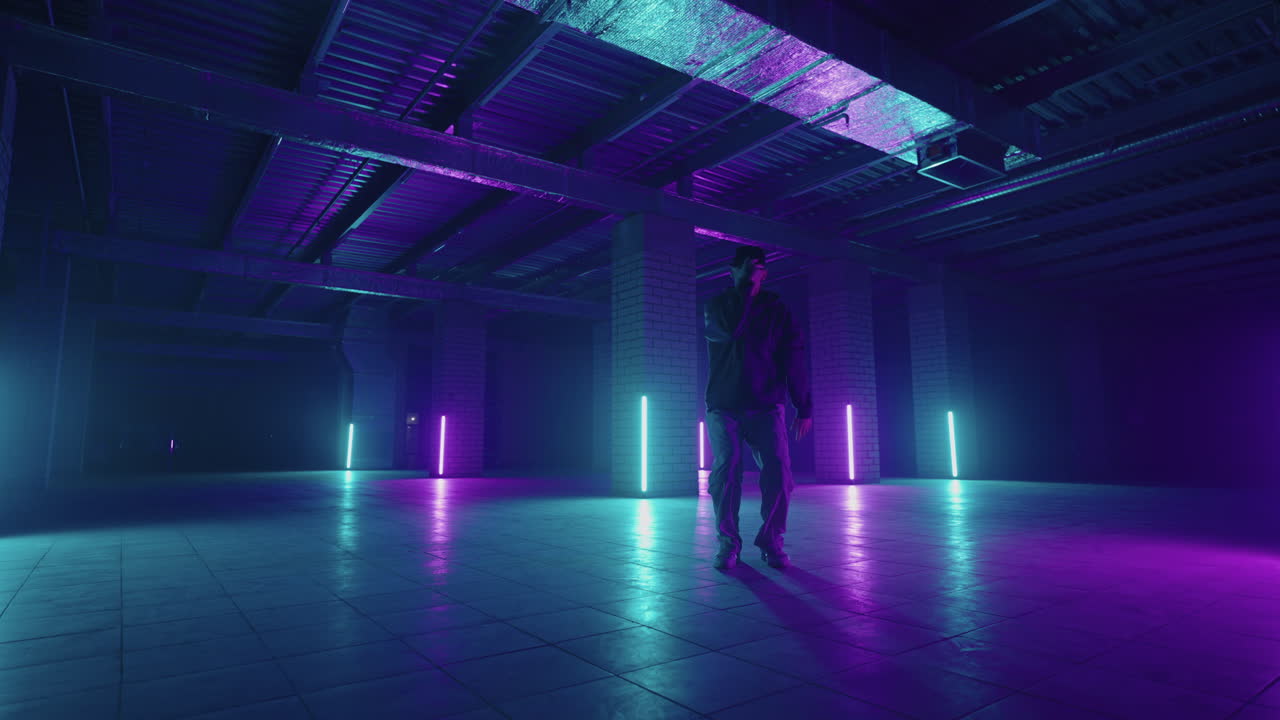 Un elegante ballerino si muove a ritmo di musica in una stanza fumosa con illuminazione al neon, esibendosi in una performance solista in stile hip hop sulla scena di un club con lampade al neon sullo sfondo.