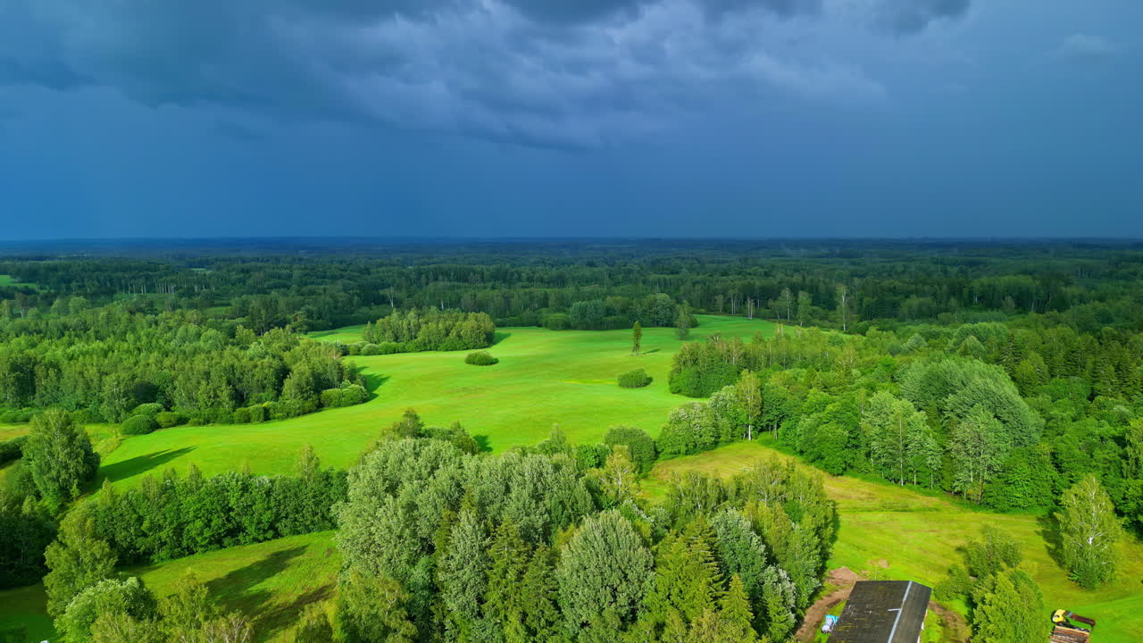 Aerial Drone's Pull-Out Shot Captures Lush Green Fields Beneath Brilliant Blue Rain Clouds