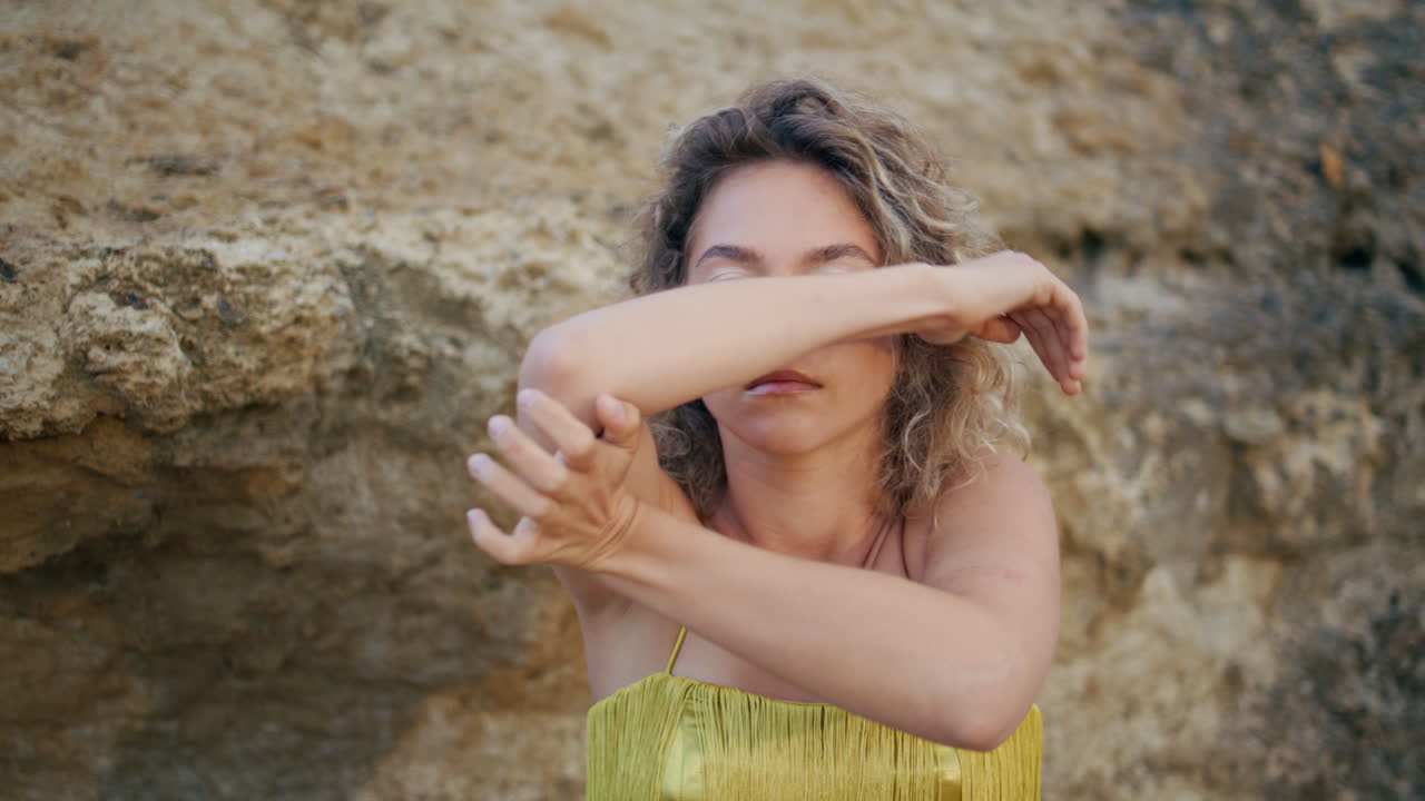 retrato de bailarina moderna moviendo las manos en una actuación sensual en la naturaleza. chica rizada