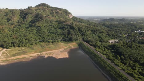 Imágenes-Aéreas-De-4k-Del-Embalse-De-Khlong-Bod-Con-Presa-Y-Carretera-Que-Conduce-A-La-Ladera-Con-árboles-Tropicales-Verdes-En-Nakhon-Nayok,-Tailandia